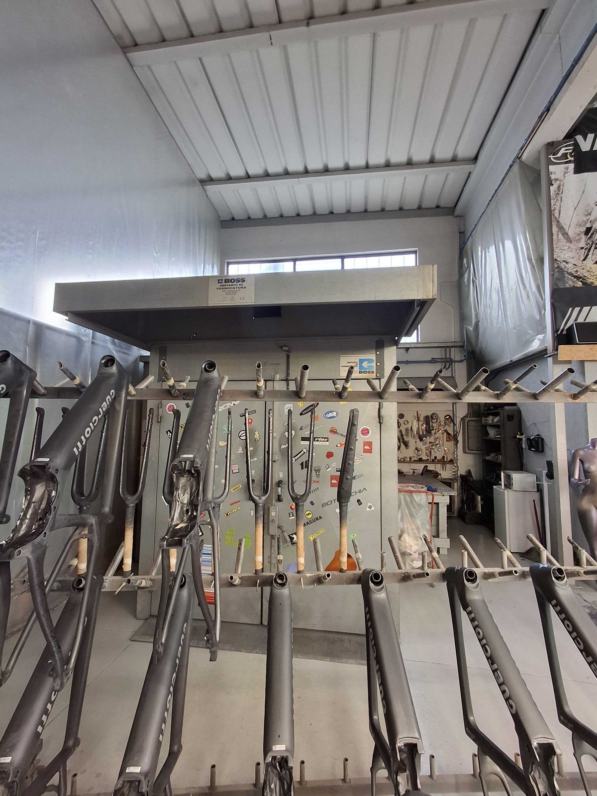 Reparto produttivo con telai e cabina di verniciatura rilevato durante il sopralluogo ErgonSì