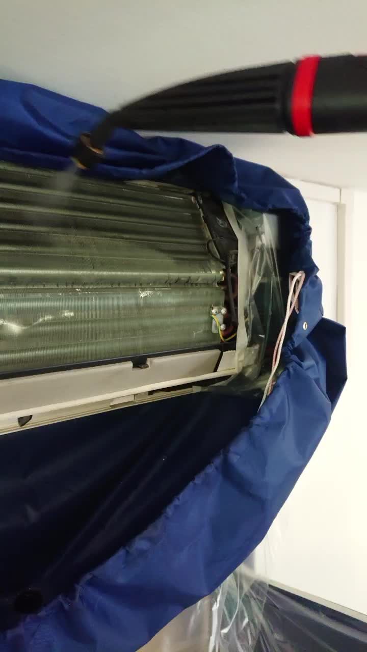 Pulizia dello scambiatore di un climatizzatore con protezione per la raccolta dell'acqua, durante un intervento ErgonSì